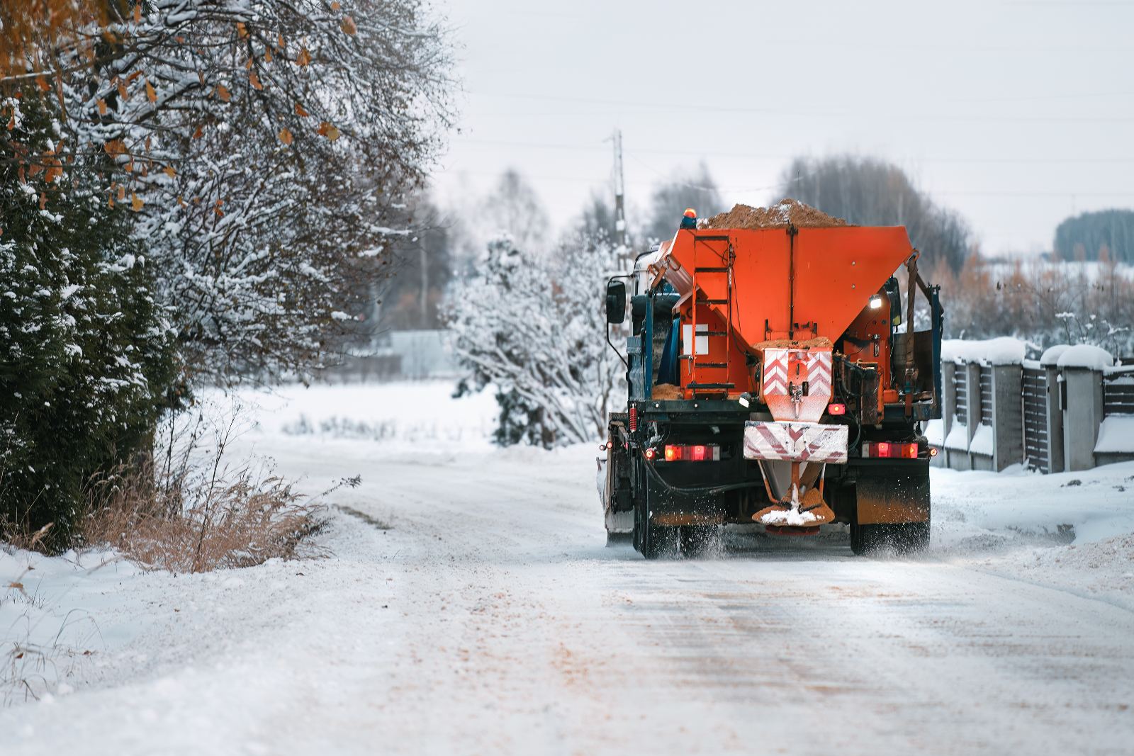 Sidewalk tractor on a city street after a snowfall