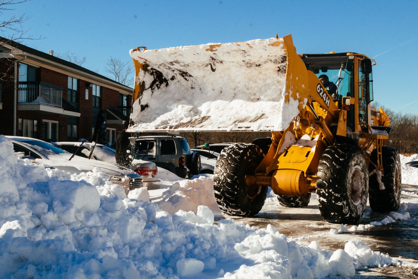 Loader stacking snow into a bank at the lot edge